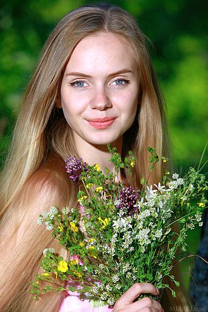 Blue-eyed blonde with perfectly small tits posing next to a tree